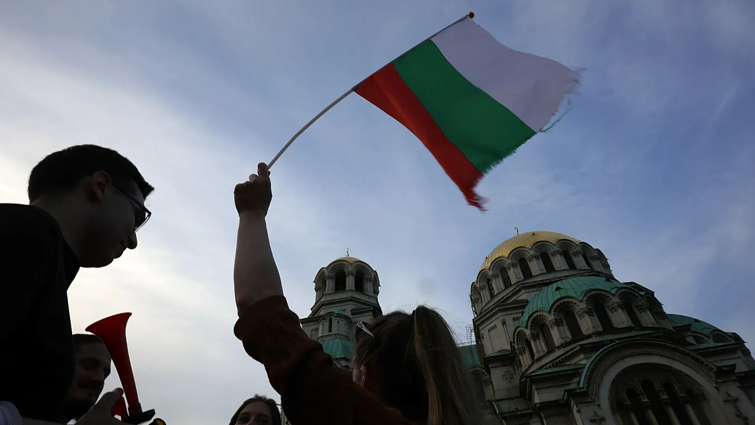  A pro-government protester holds a Bulgarian flag during a demonstration in support of incumbent Bulgarian government near the Bulgarian Parliament in Sofia, 21 June 2022.