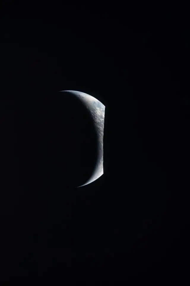 La Tierra asomándose detrás de la Luna.