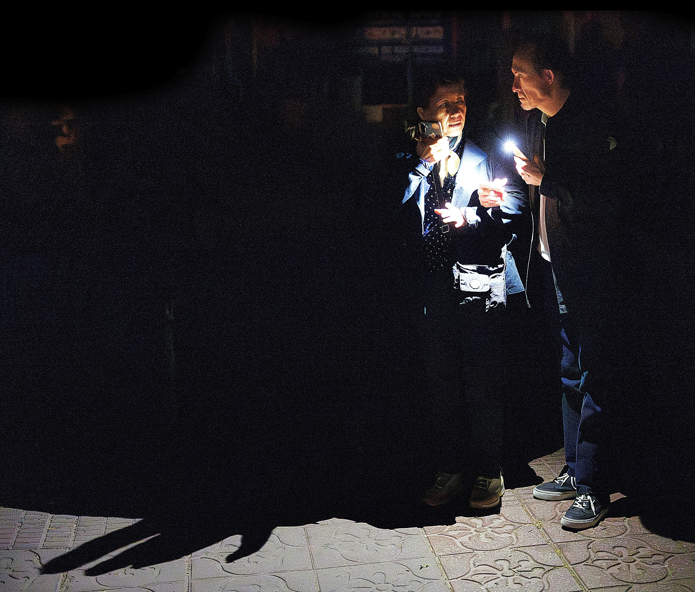 Dos personas iluminan con linternas durante el apagón de 2025 en Madrid.