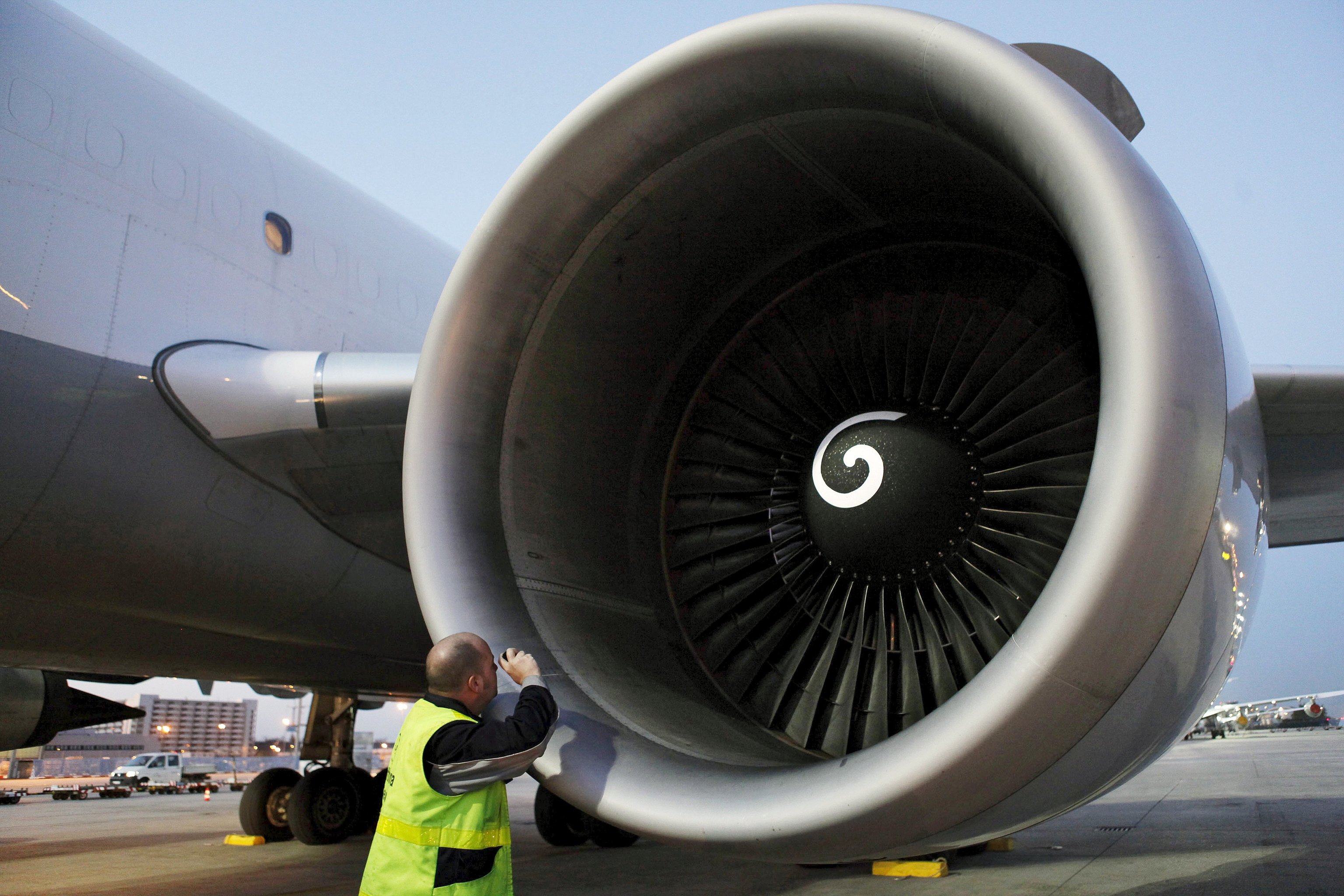 Un técnico de un aeropuerto revisando una turbina de un avión en Barajas.