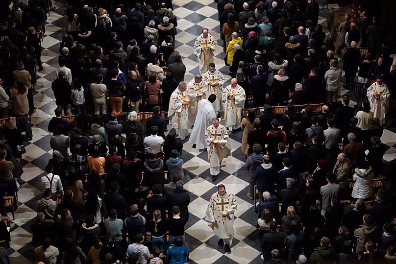 Clergymen give the Eucharist during the first public mass in Notre Dame Cathedral since the 2019 fire, 8 December, 2024 