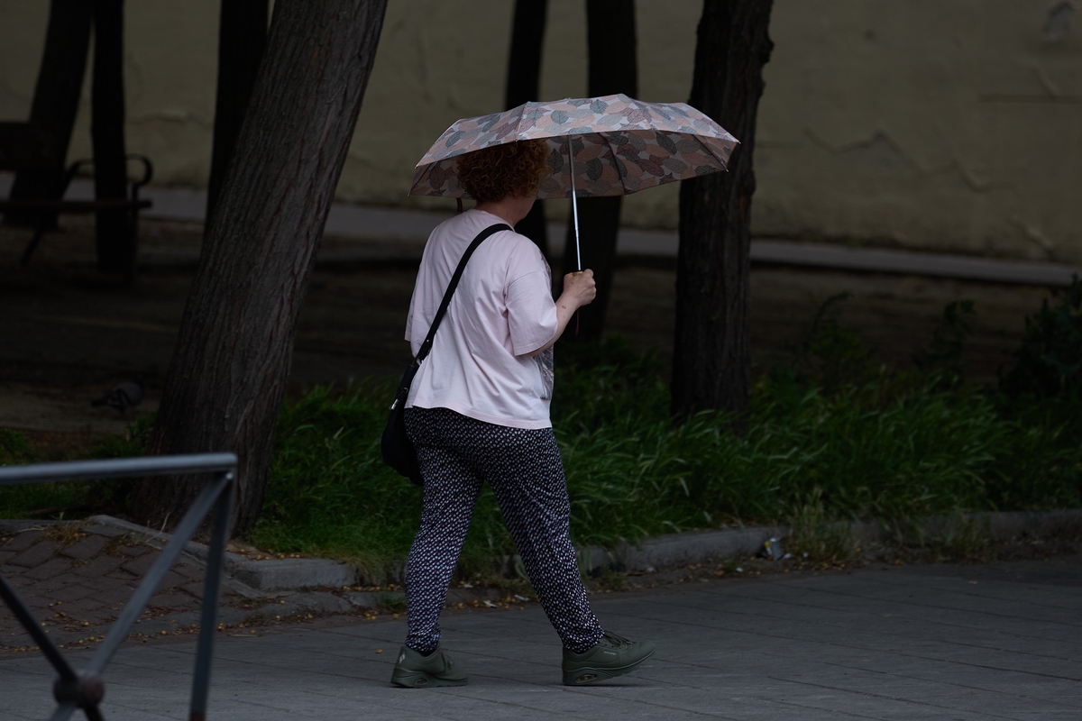 Imagen de archivo de una mujer que se protege de la lluvia con un paraguas, a 8 de junio de 2024, en Madrid (España). (Jesús Hellín/Europa Press)