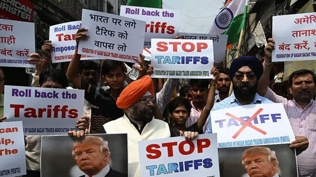 Manifestantes portan pancartas con los lemas "Alto a los aranceles" y "Revocación de los aranceles", con la imagen de Donald Trump, durante una protesta contra los aranceles del 50% impuestos por el presidente estadounidense a India