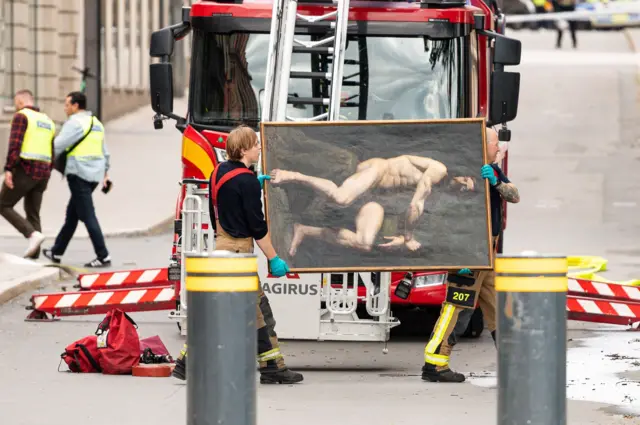 Los bomberos rescatan una pintura cuando estalla un incendio en la Real Academia de Bellas Artes, en el centro de Estocolmo.