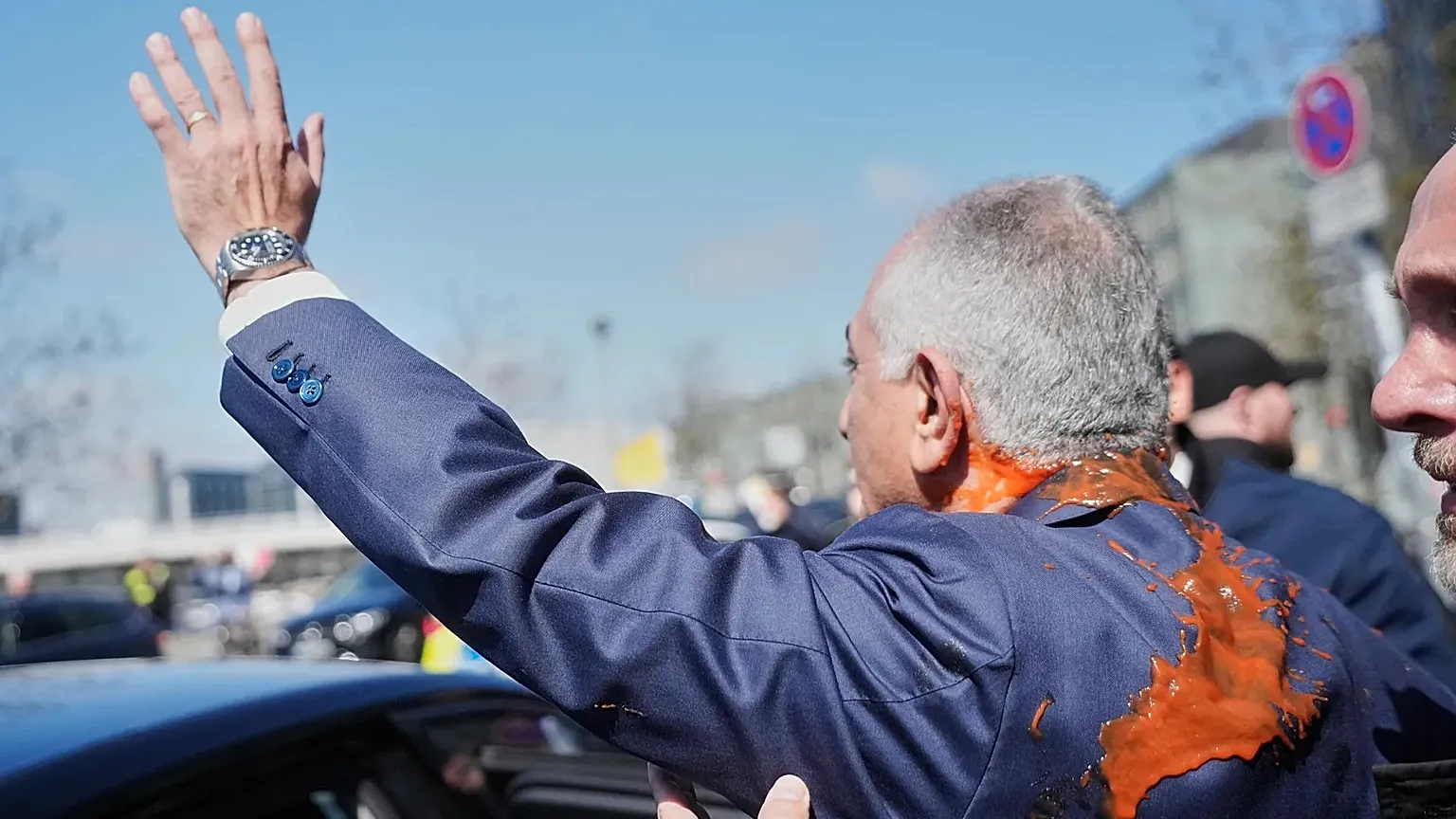 Iran's Reza Pahlavi, exiled son of Shah Reza Pahlavi, waves to supporters after he was attacked with a red fluid following a news conference in Berlin, 23 April, 2026