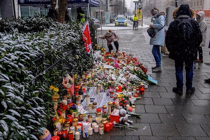 Flowers and candles were laid near the spot where a car drove into a group of protesters in February 2025 three days after the attack,