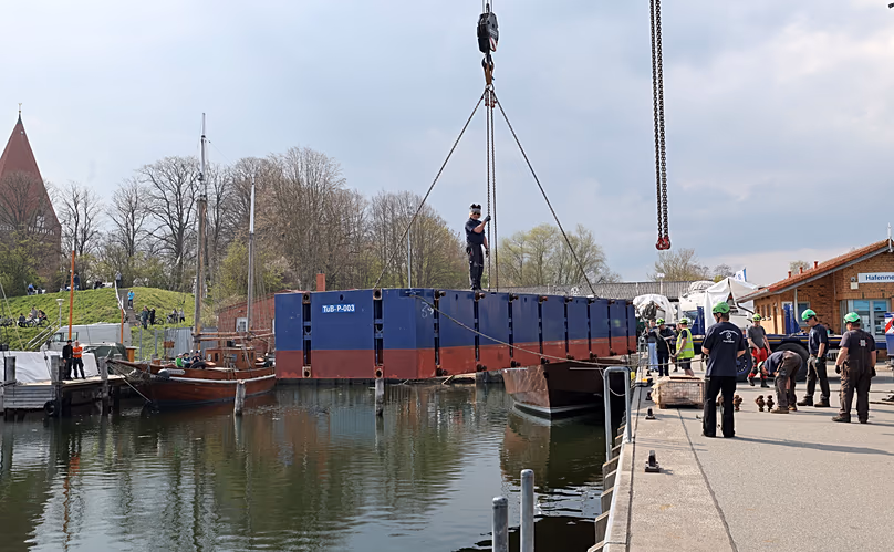 One part of the four parts for the pontoon which are to be used to rescue the stranded humpback whale are lifted into the water with cranes in the port of Kirchdorf, 16 April,
