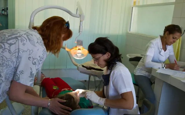 Un grupo de enfermeras revisan a una niña acostada en una camilla