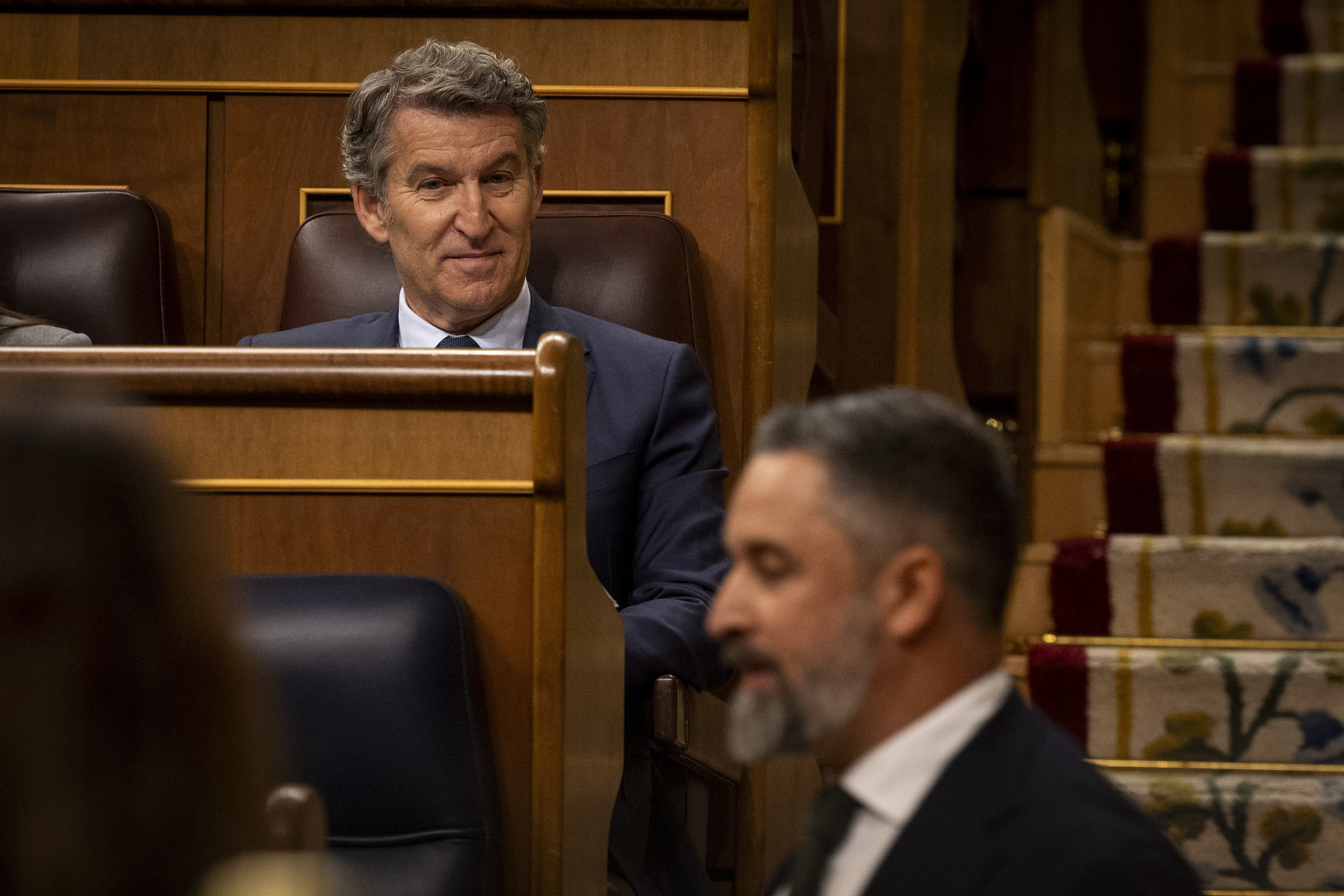 Alberto Núñez Feijóo, en su escaño mira a Santiago Abascal.