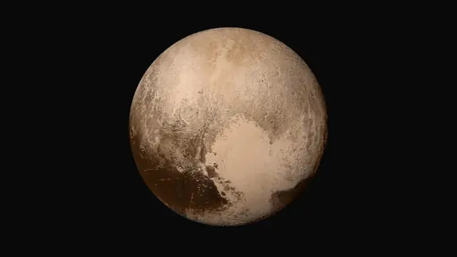 Plutón se ve como una esfera parduzca sobre un fondo negro, con zonas de colores más oscuros y más claros en su superficie.