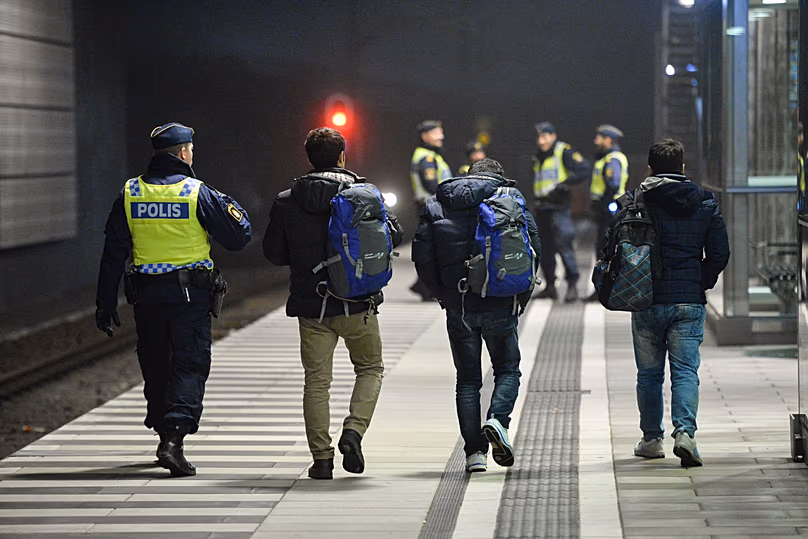 Police escort three men from a train at Hyllie station, 17 December, 2015