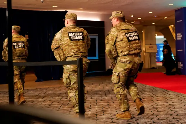 Miembros de la Guardia Nacional corriendo por los corredores del evento
