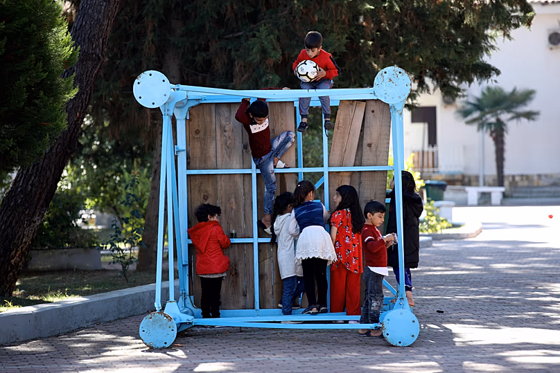 Children play at a coastline tourist resort in Golem, 27 October, 2021