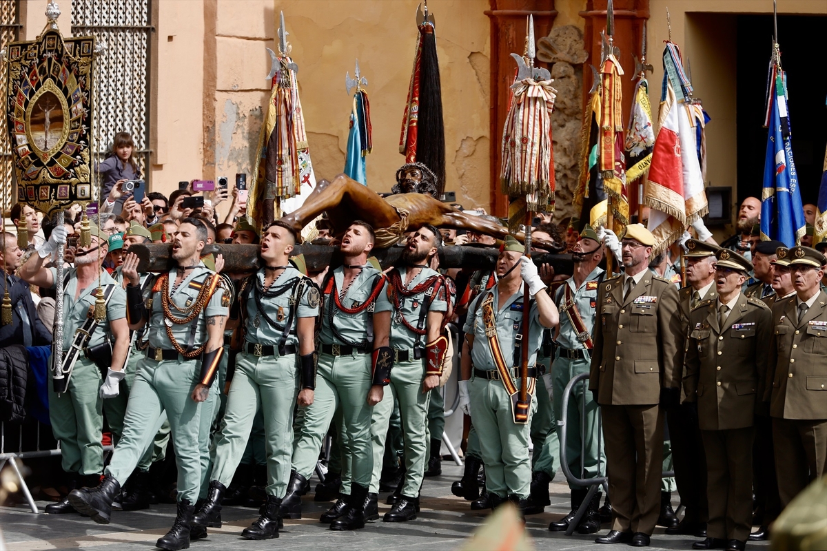 Imágenes de los legionarios portando al Cristo de Mena, en Málaga, el Jueves Santo. Álex Zea / Europa Press.