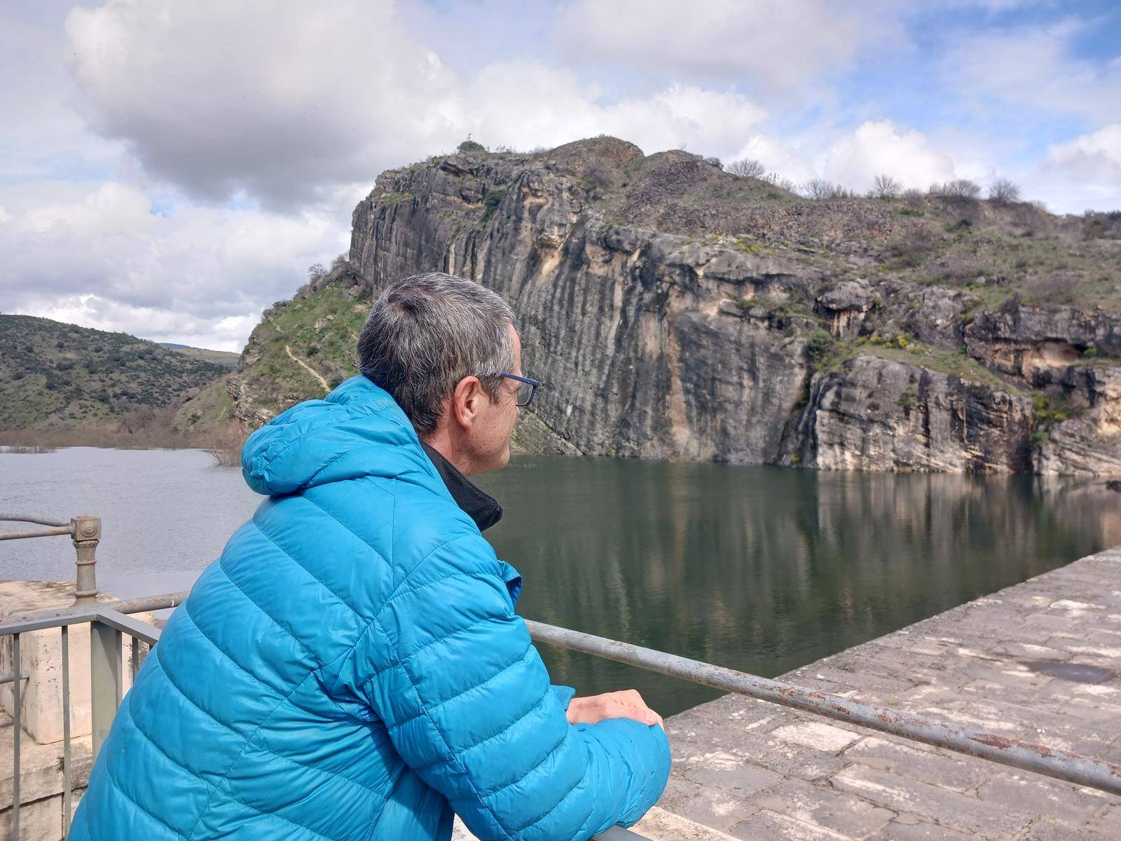 Foto: Un senderista mira hacia los cortados rocosos sobre el embalse en la Sierra de Ayllón. (Wikiloc)