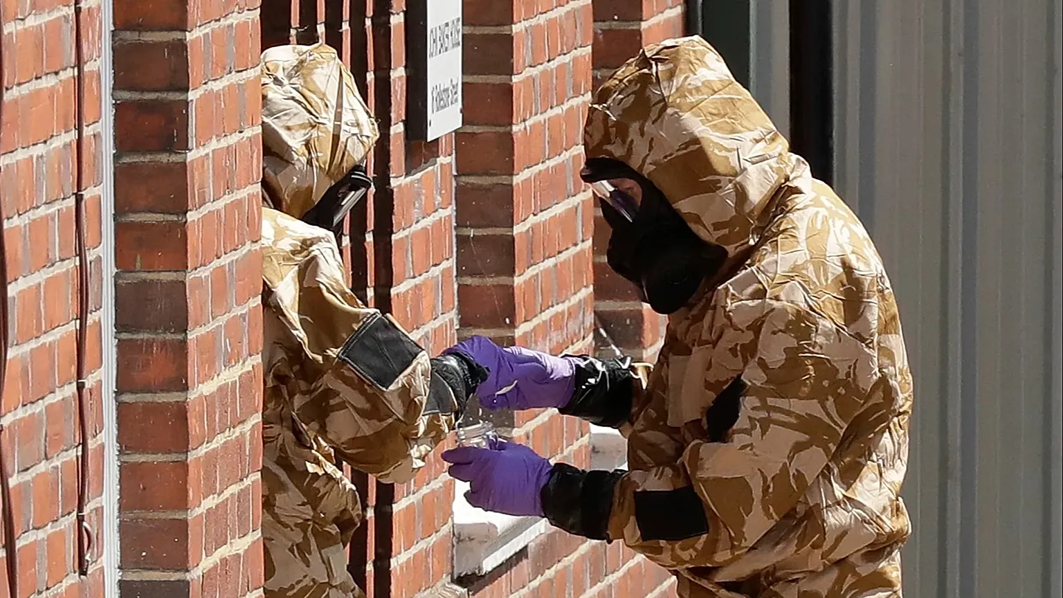 Emergency workers in military protective suits search the fenced off John Baker House for homeless people on Rollestone Street in Salisbury, 6 July, 2018