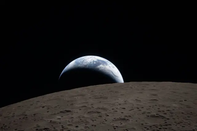 Imagen de la salida de la Tierra asomando sobre la superficie de la luna.