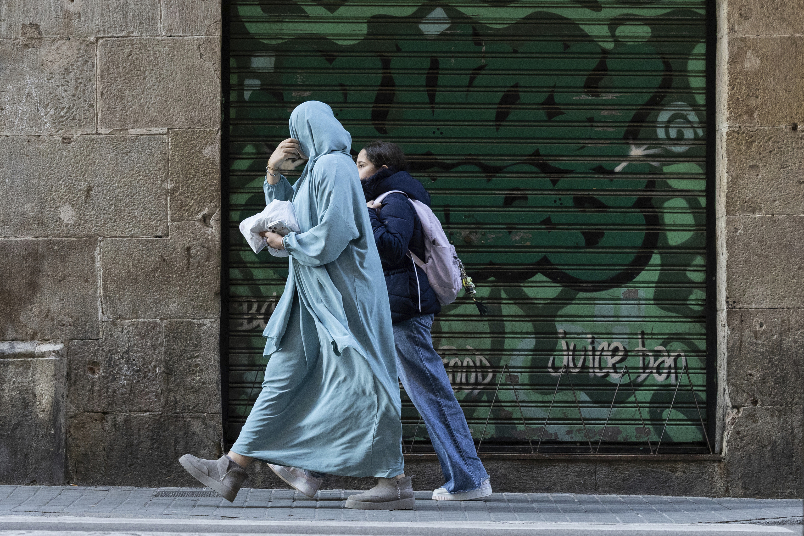 Una mujer vestida con velo integral paseando por Barcelona.