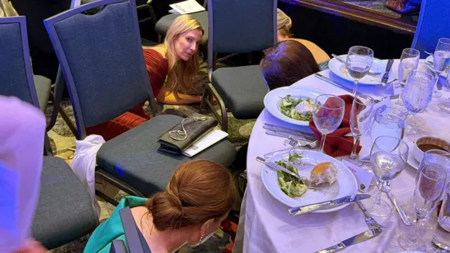 Los invitados buscan refugio cerca de una mesa tras escucharse disparos durante la cena de la Asociación de Corresponsales de la Casa Blanca, celebrada en el hotel Washington Hilton de la capital estadounidense.