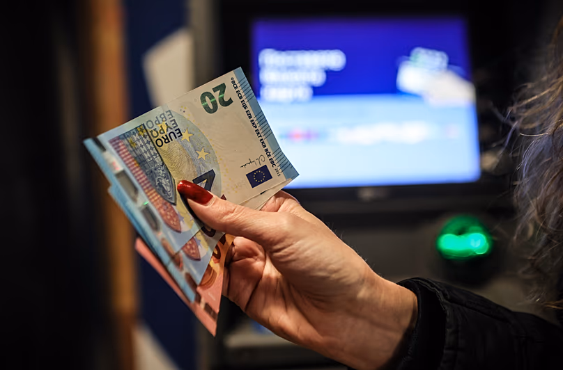 A person poses with euro banknotes withdrawn from an ATM in Sofia, 1 January, 2026