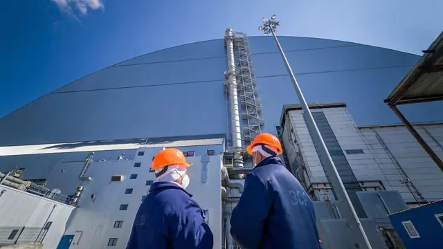 El arca de protección frente al cual se encuentran dos trabajadores con cascos naranjas.