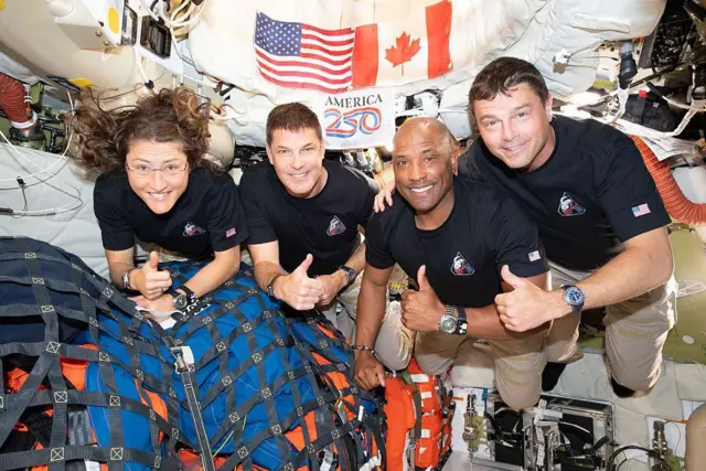 Los cuatro integrantes de la tripulación de Artemis II posan con el pulgar levantado mientras flotan en el interior de la nave espacial.