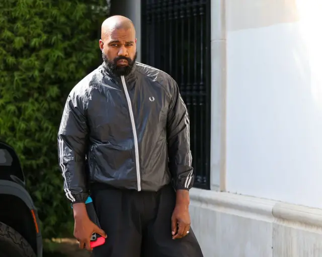Kanye West en ropa deportiva en la calle.