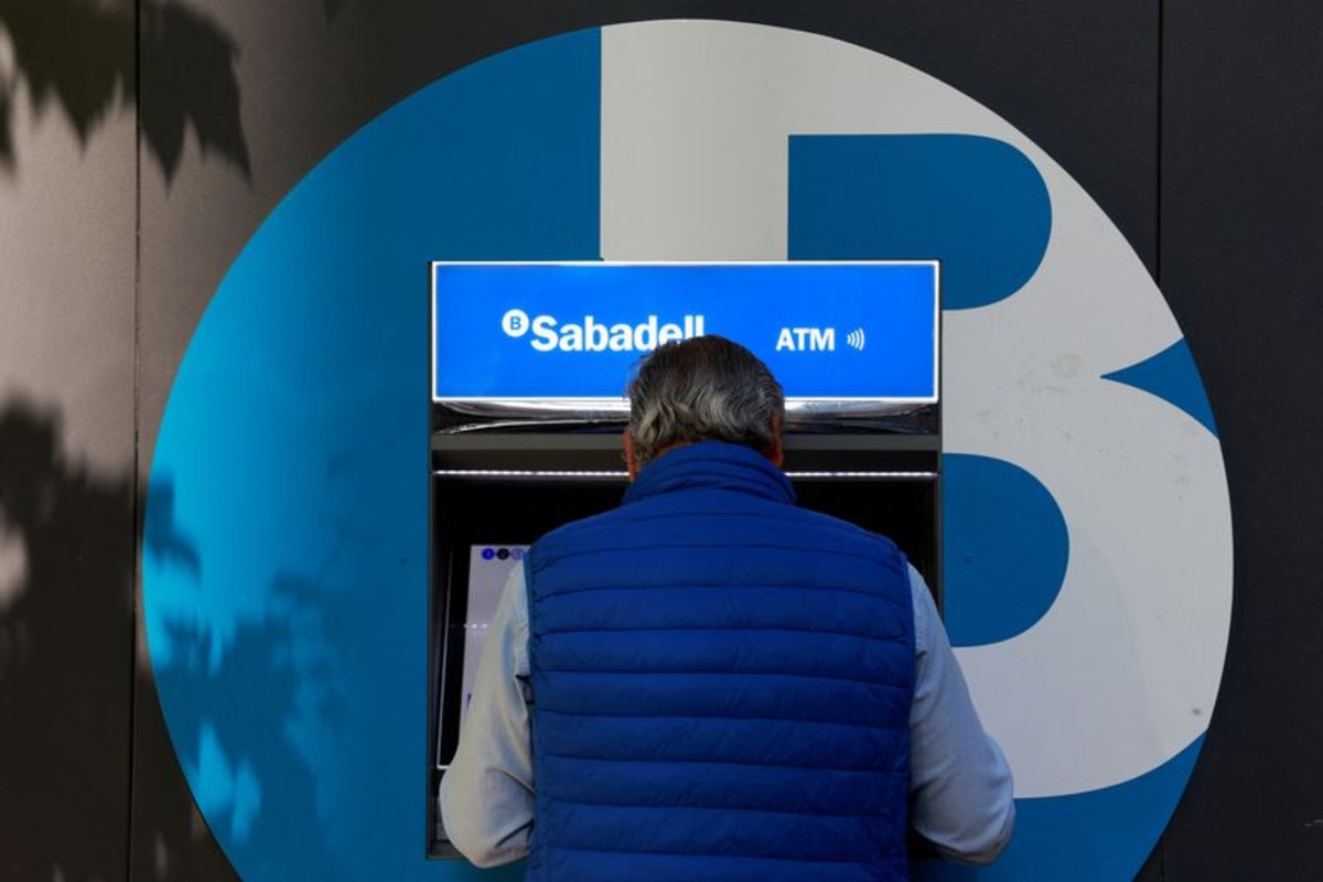 Un hombre utiliza un cajero automático en una sucursal del banco Sabadell en Madrid, España. REUTERS/Susana Vera