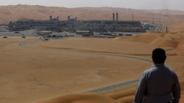 Un hombre de espaldas observa desde lejos el centro de producción de gas licuado en el yacimiento de Shaybah, en Arabia Saudita