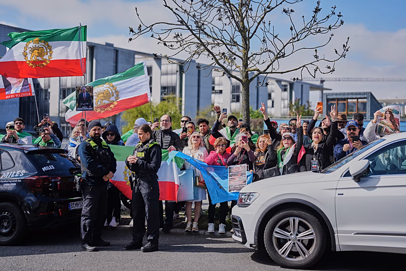 Supporters of Reza Pahlavi shout slogans outside the building where he held a news conference in Berlin, 23 April, 2026