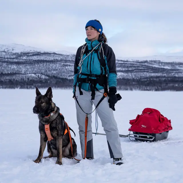 Eva zu Beck con un trineo y un perro en un paisaje de nieve