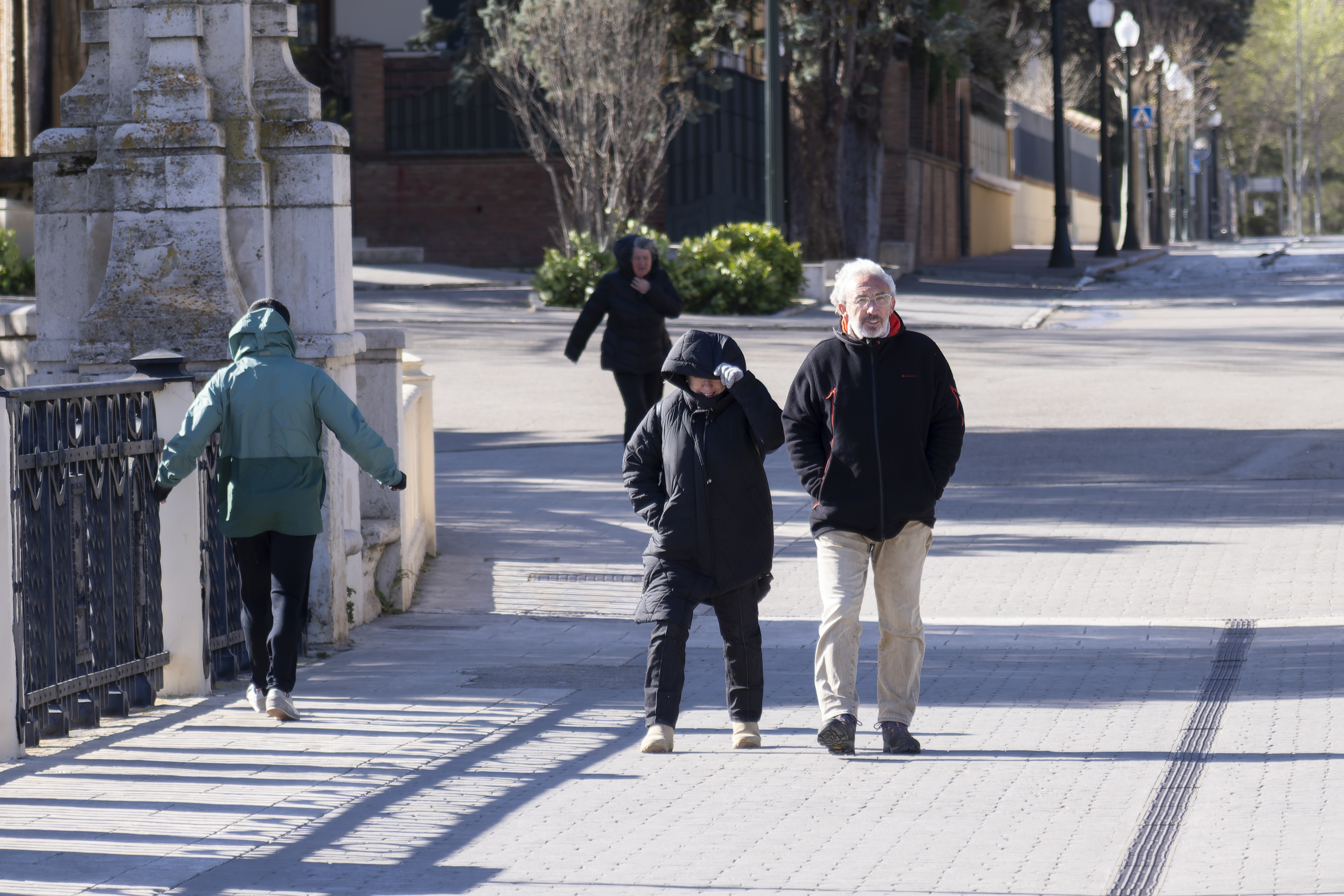Varias personas protegiéndose del fuerte viento de este domingo en Teruel.