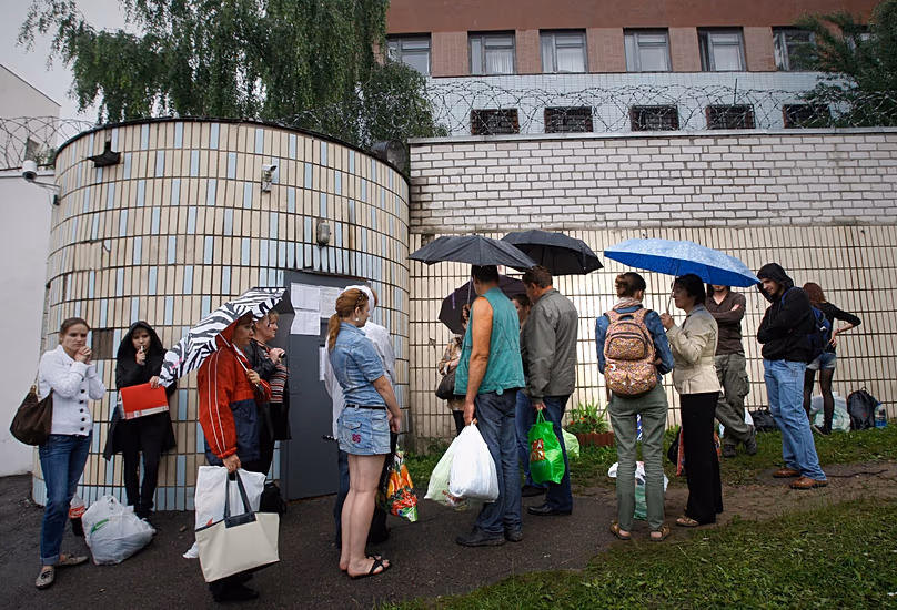 Relatives and friends of arrested participants of a flash mob wait outside the prison walls to bring food and clothes in Minsk, 7 July, 2011