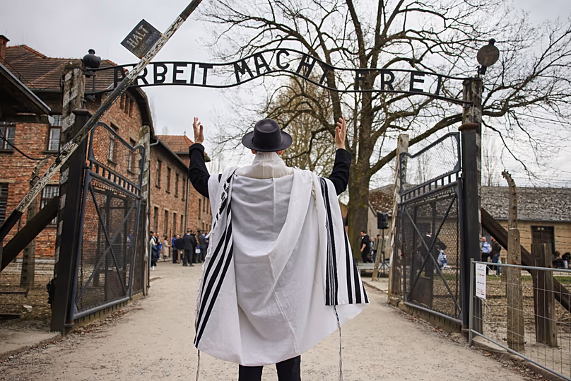 A man stands in front of the Auschwitz entrance prior to the annual "March of the Living" to commemorate the Holocaust in Oświęcim, 14 April, 2026