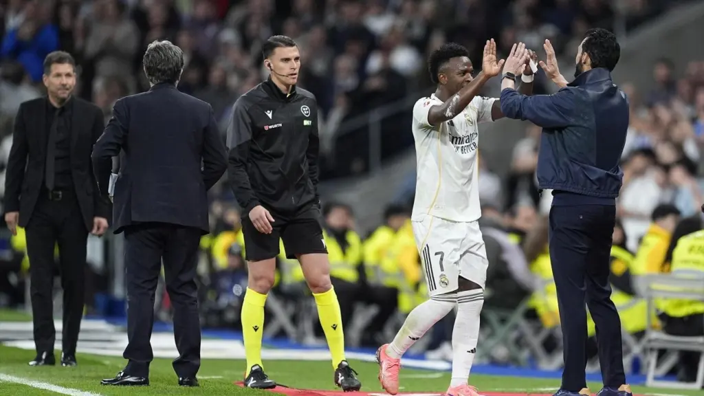 Vinicius y Arbeloa se saludan en el derbi ante el Atlético de Madrid.
