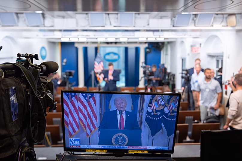 US President Donald Trump is seen speaking about the Iran war on a television screen in the James Brady Press Briefing Room of the White House, 1 April, 2026