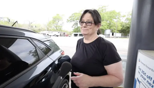 La conductora estadounidense Donna es entrevistada mientras llena el tanque de su coche.