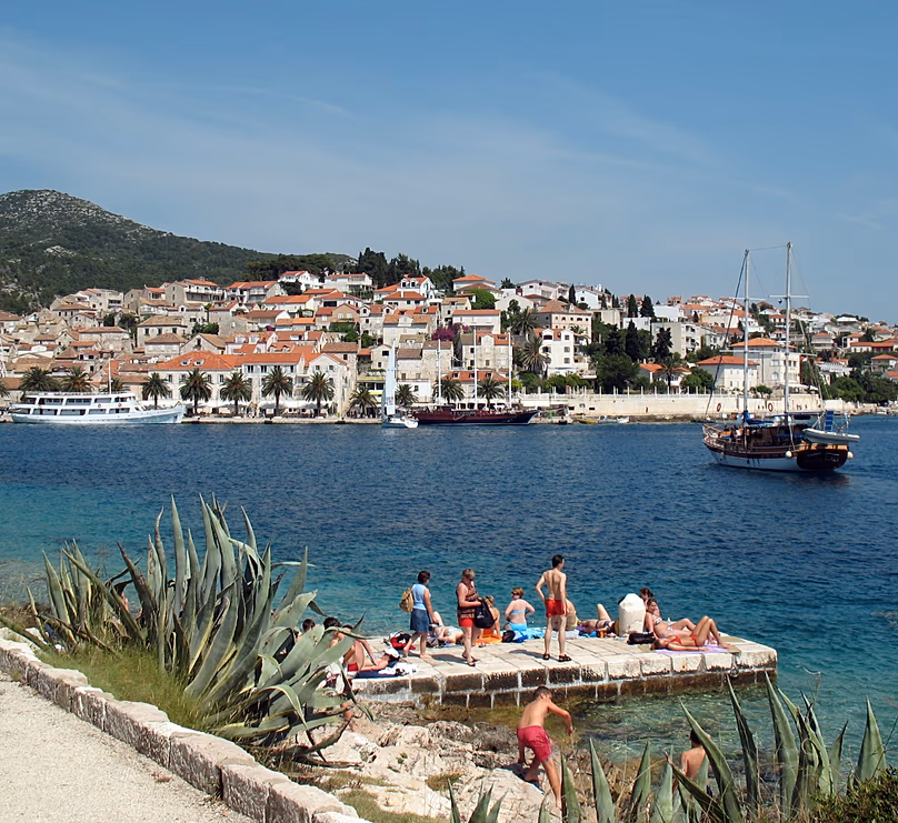 Turistas tomando el sol en el puerto de Hvar, Croacia