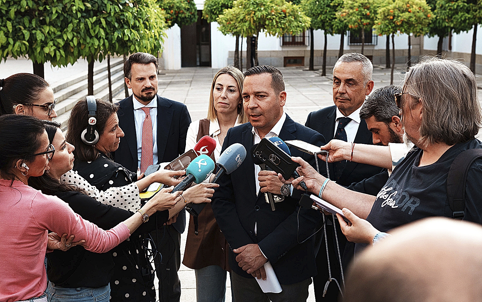 Óscar Fernández (Vox) atendiendo a los medios tras alcanzar el acuerdo. Detrás, la presidenta en funciones de la Junta, María Guardiola.