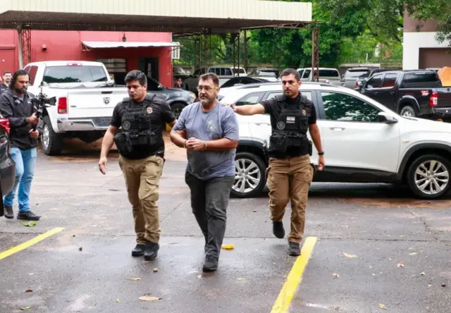 Foto de Marcos siendo arrestado por la policía paraguaya.