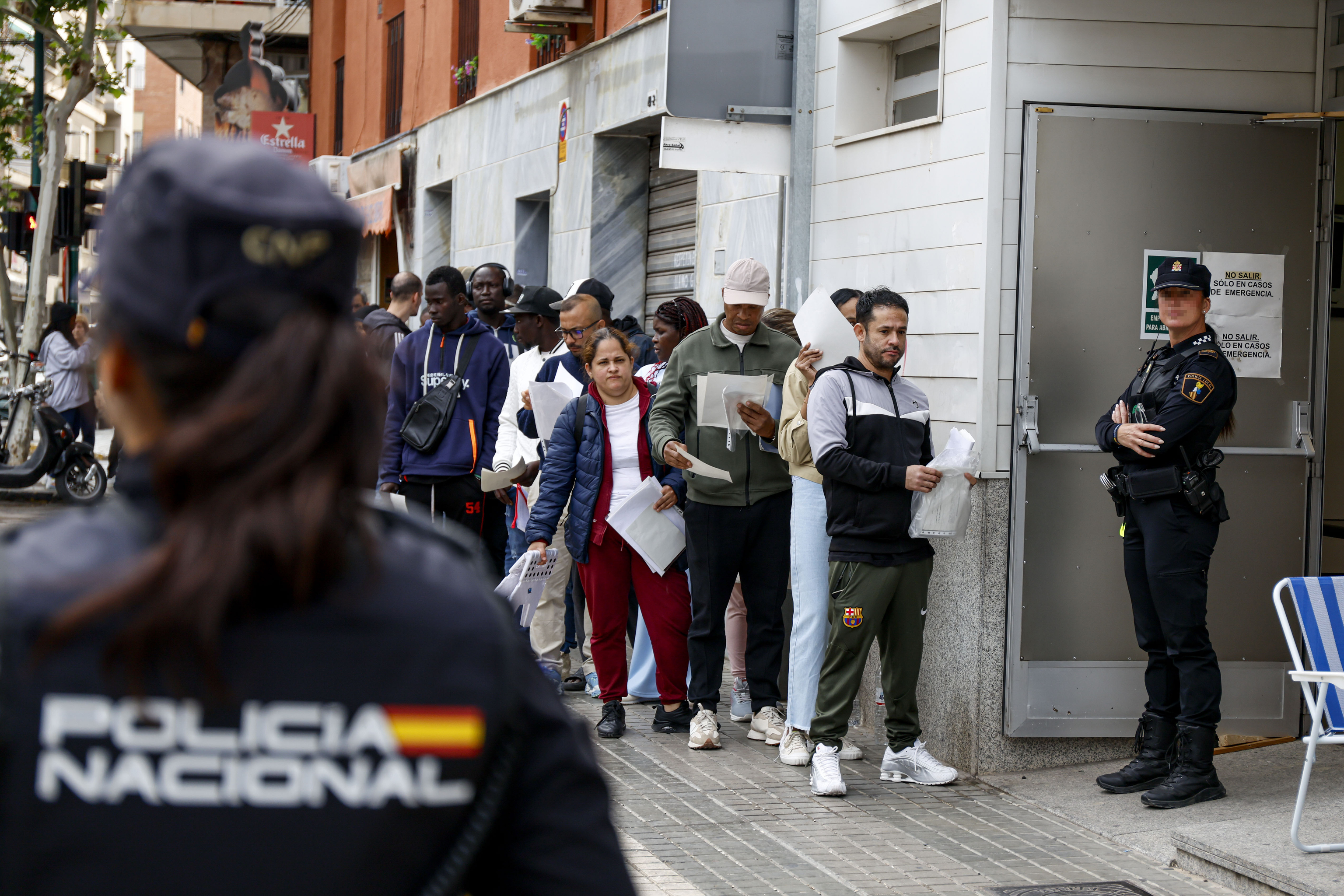 Decenas de personas hacen cola para presentar documentación dentro de su proceso de regularización