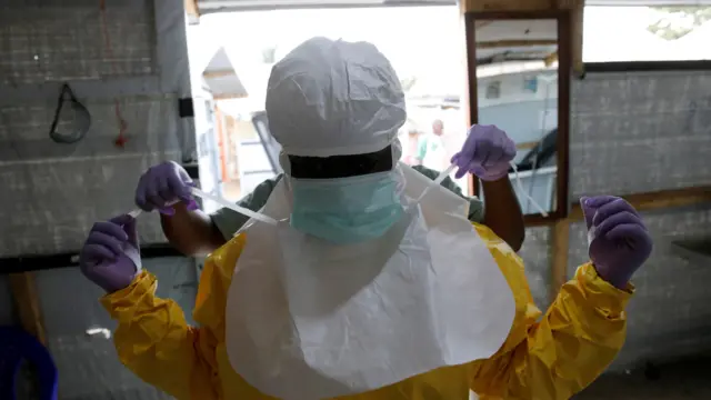 Un trabajador sanitario se pone el equipo de protección contra el ébola antes de entrar en la unidad de cuidados de emergencia de un centro de tratamiento del ébola en Beni, en la República Democrática del Congo.