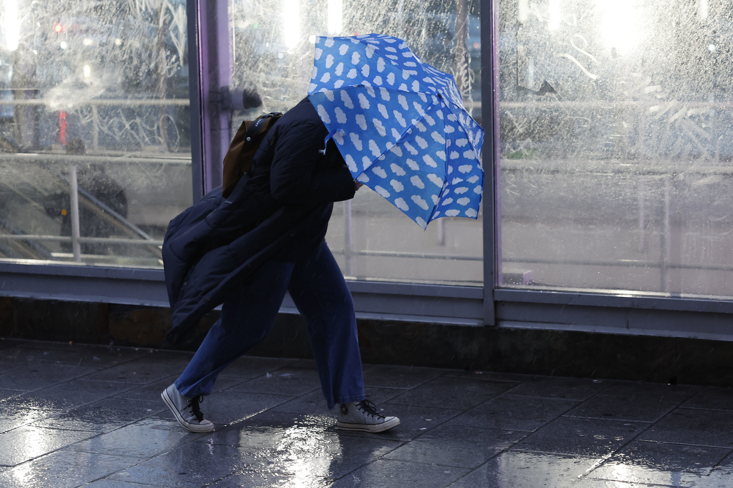 Una persona se protege de la lluvia en Madrid.