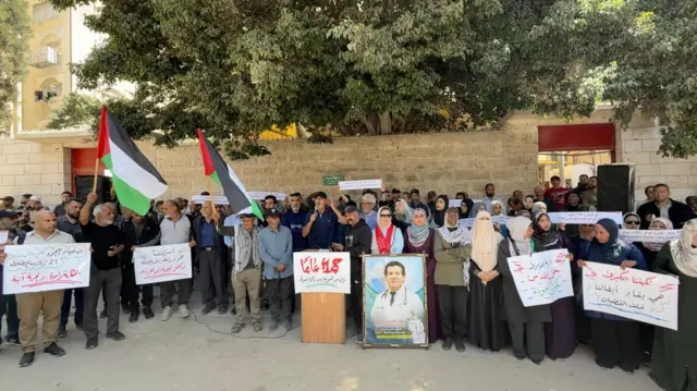Manifestantes que hacen campaña contra la nueva ley israelí con carteles y banderas palestinas en la Ciudad de Gaza.