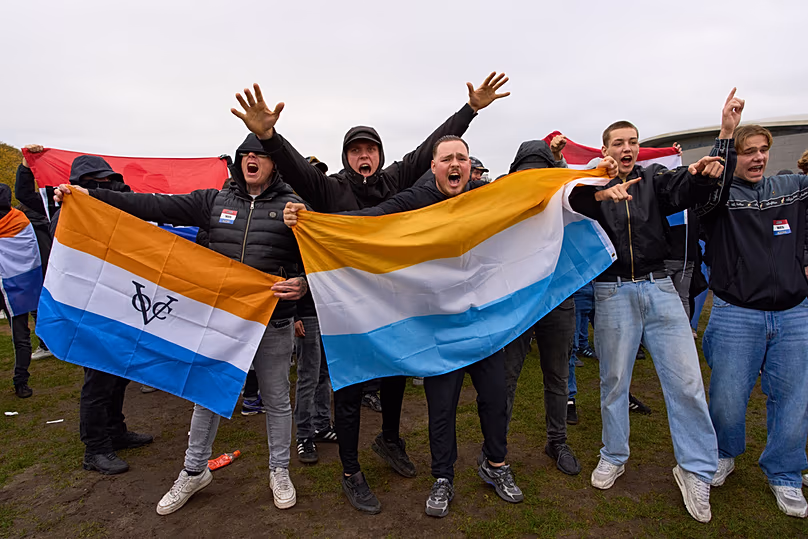 ARCHIVO - Manifestantes antiinmigración con la Prinsenvlag durante una protesta en Ámsterdam, 12 de octubre de 2025