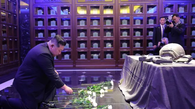 Kim Jong Un deposita flores blancas dentro del columbario, que contiene filas de urnas en su interior.