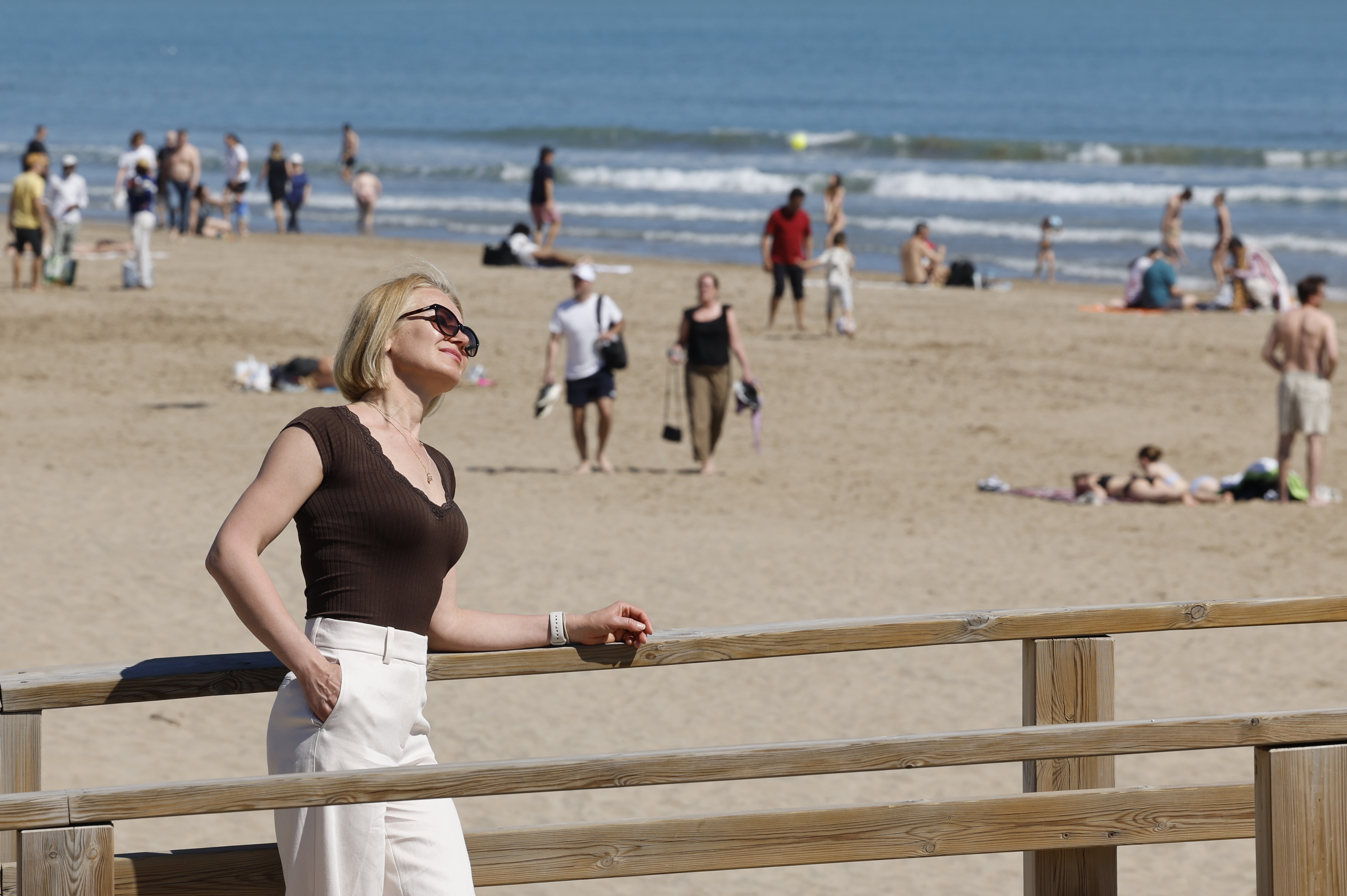 Residentes y turistas disfrutan del sol en la Playa de Las Arenas, en Valencia.