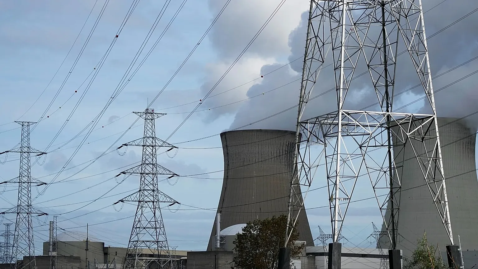 Steam billows from a nuclear power plant next to utility lines in Doel, 11 October, 2021