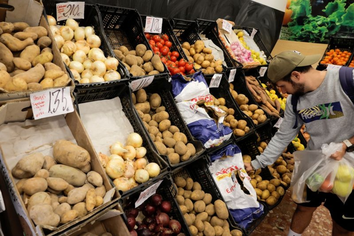 Un cliente compra patatas en una frutería, en Ronda, Andalucía, España. (REUTERS/Jon Nazca)