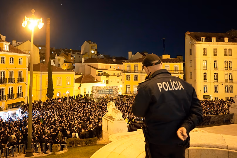 A policeman on duty on the steps of the Portuguese parliament watches thousands of people protest for better salaries and work conditions in Lisbon, 24 January, 2024